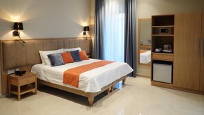 A modern hotel room with a large bed, bedside lamps, a wardrobe, and a small kitchenette. - Duncan guest house (Marsaxlokk)