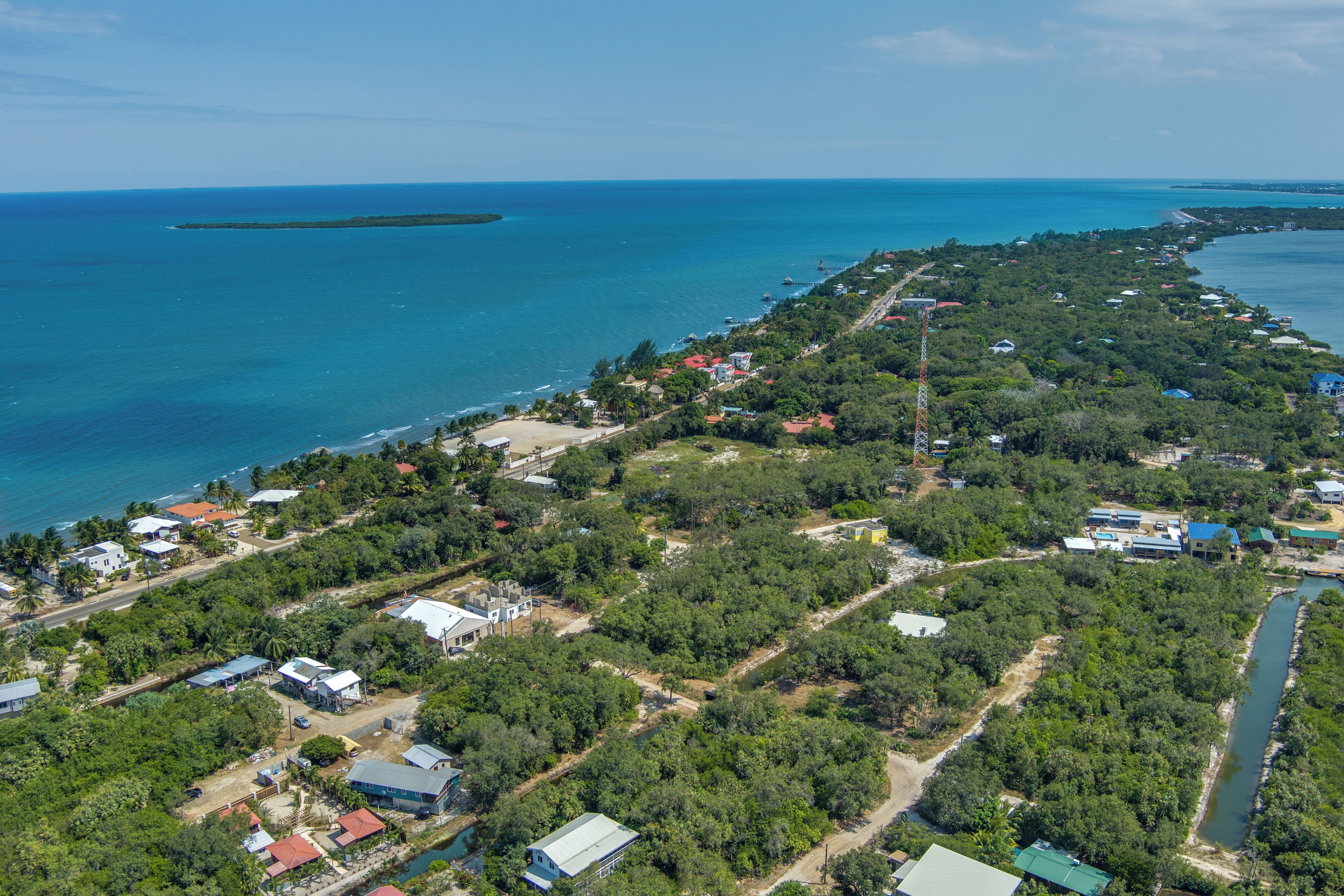 An aerial view of a coastal area with buildings, roads, and a river.