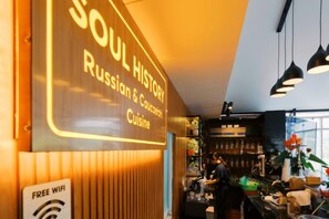 A restaurant interior with a sign indicating 'SOUL HISTORY Russian & Caucasian Cuisine' and a 'FREE WIFI' sign. - Soul History Hotel Phu Quoc (Phu Quoc Island)