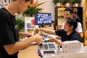 Une personne utilise un ordinateur portable à un comptoir, avec un écran en arrière-plan.