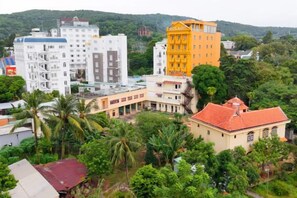 A multi-story building with a flat roof, surrounded by greenery and other buildings. - Soul History Hotel Phu Quoc (Phu Quoc Island)