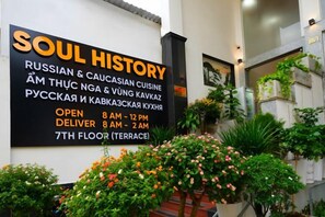 A signboard for 'SOUL HISTORY' with Russian and Caucasian cuisine options, open from 8 AM to 12 PM, and delivery from 8 AM to 2 AM on the 7th floor. - Soul History Hotel Phu Quoc (Phu Quoc Island)