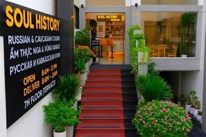 Entrada de un edificio con un cartel que anuncia 'SOUL HISTORY', ofreciendo cocina rusa y del Cáucaso.