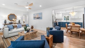 A modern living room with a sofa, coffee table, and dining area.