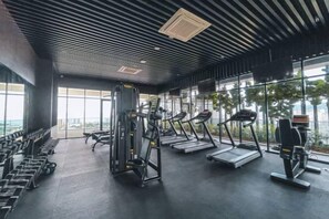 Un gimnasio con cintas de correr, máquinas de pesas y mancuernas.