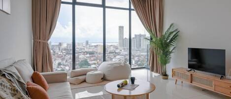 A modern living room with a sofa, a coffee table, and a TV.
