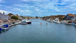 A marina with boats docked, a clear sky, and buildings along the waterfront. - Seascape Estate - Steps To Harbor Beach, Pool, Spa (Huntington Beach)
