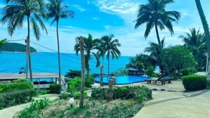 Ein Resort mit Palmen, einem Pool und Blick auf den Ozean.