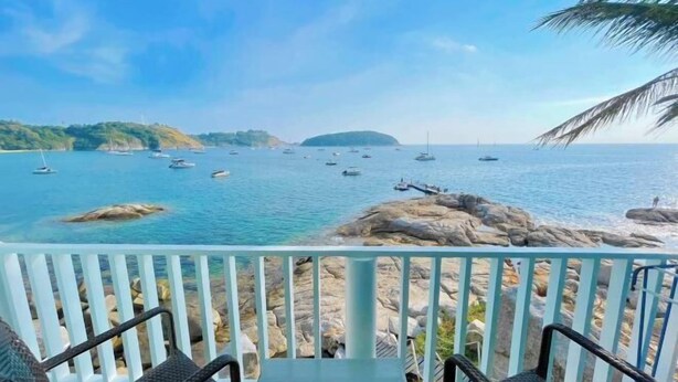 Ein Balkon mit Blick auf das Meer, Boote und eine felsige Küste.