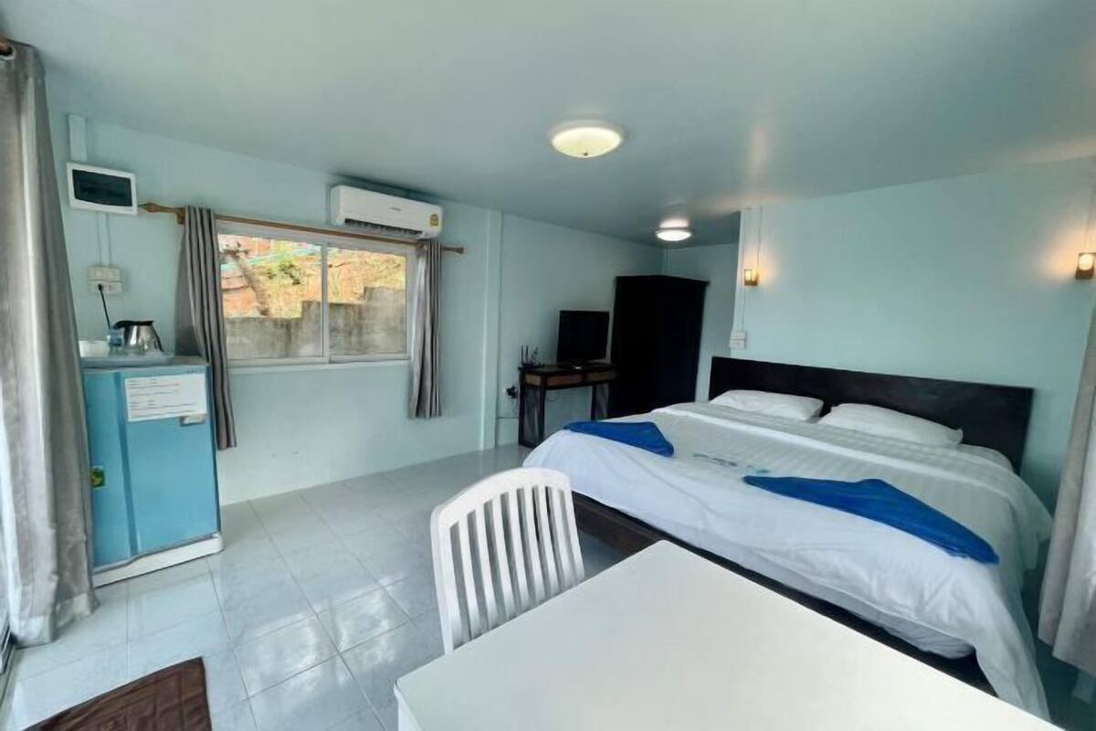 Une chambre d’hôtel équipée d’un lit, d’un bureau, d’une chaise et d’une petite kitchenette.
