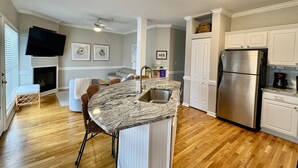 A modern kitchen with a central island, built-in appliances, and a cozy seating area.