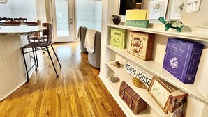 A kitchen with a dining area, a bookshelf with books and decorative items, and a view of the living room.