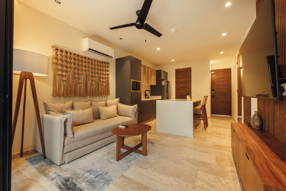 A modern living room with a sofa, coffee table, and a ceiling fan.