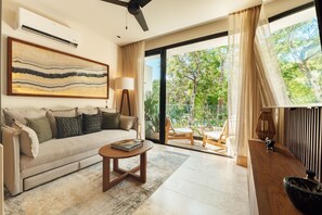 A modern living room with a sofa, coffee table, and a painting on the wall. - 101 Park Tulum by Lumina (Tulum)