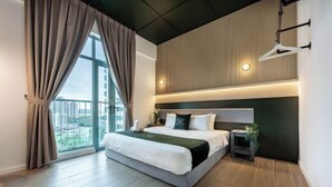 Una habitación de hotel moderna con una cama grande, una mesita de noche, una lámpara colgante y vistas a la ciudad.