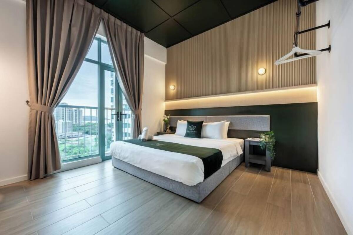 Une chambre d’hôtel moderne avec un grand lit, une table de chevet, une lampe suspendue et une vue sur la ville.