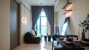 Una sala moderna con sofá, mesa de comedor y vistas al exterior.