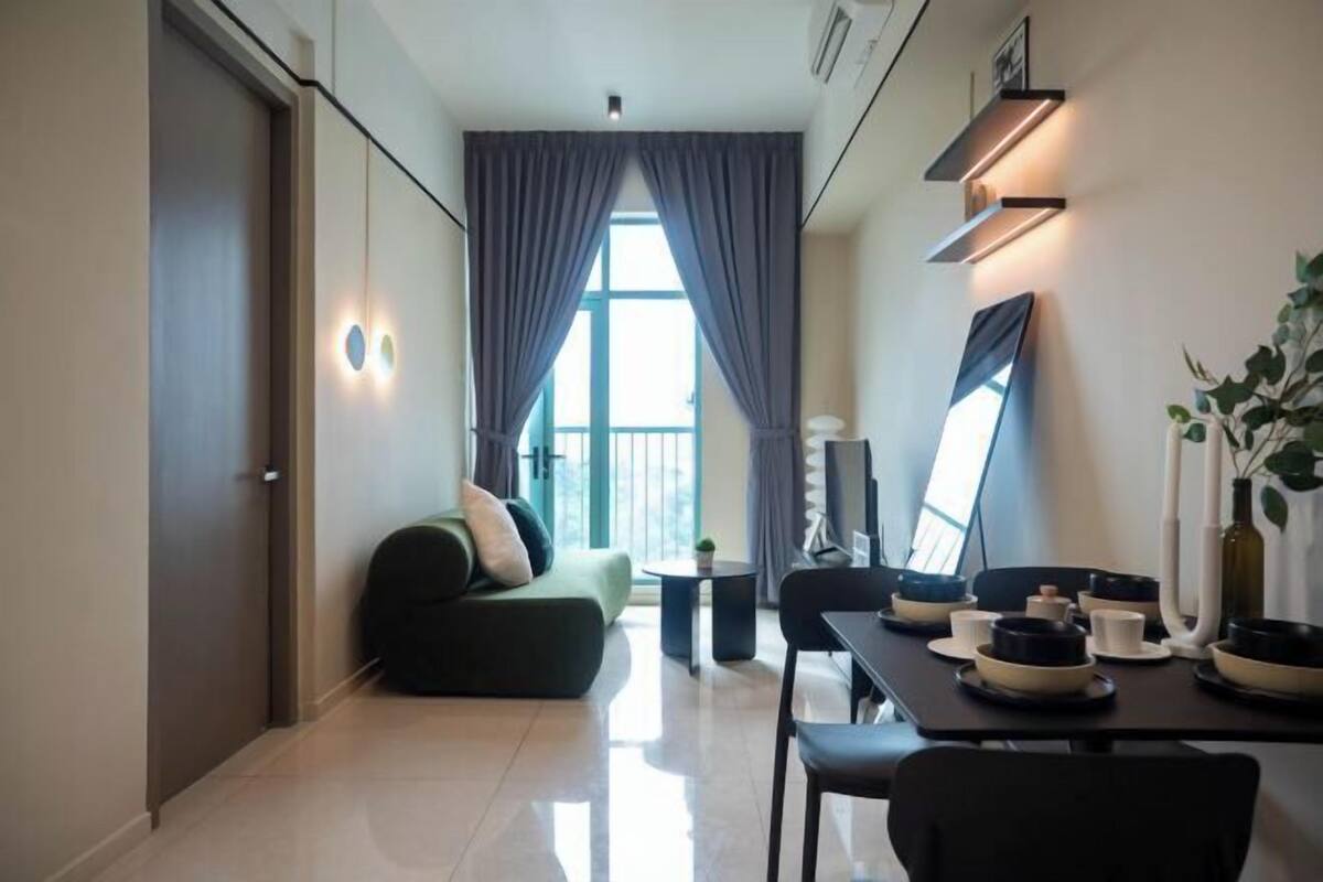 Un salon moderne avec un canapé, une table à manger et une vue sur l’extérieur.
