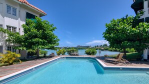 Une piscine avec vue sur un lac et des bâtiments en arrière-plan.