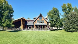 Een lodge met een ruim terras, buitenzitplaatsen en een verzorgd gazon.