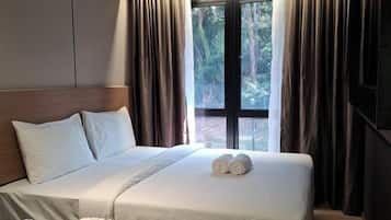 Une chambre d’hôtel avec un lit, des rideaux, une fenêtre et une table de chevet avec quelques objets.