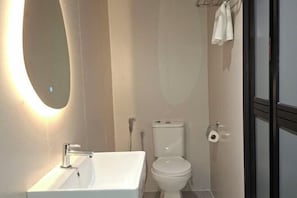 A bathroom with a white sink, toilet, and shower. - Urban Inn Cyberjaya (Cyberjaya)