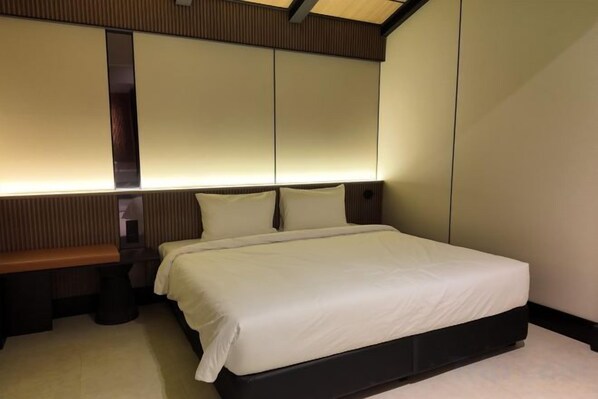 A neatly made bed with a headboard, a bedside table, and a bench.