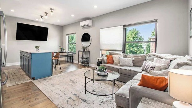 Un salon moderne avec un canapé, une table basse et un téléviseur fixé au mur.