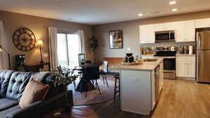 A modern kitchen with white cabinets, stainless steel appliances, and a central island.