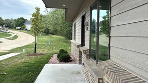A building with a covered porch, a brick lower section, and large windows. - Accessible Escape- Completely Handicap accessible! (Council Bluffs)