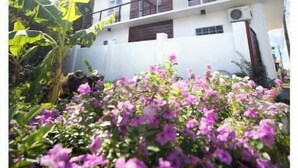 A modern two-story building with a white facade, balconies, and an air conditioning unit. - Irie Heights Oceanview (Gros Islet)