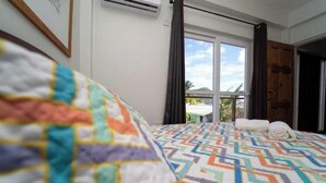 Ein Hotelzimmer mit Bett, einem Fenster mit Vorhängen und einer Tür.