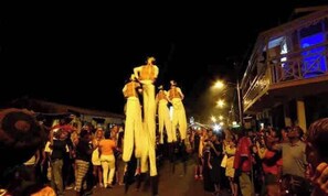 A nighttime outdoor event with people gathered around a central figure.