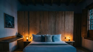 Une chambre à coucher avec un grand lit, des murs en bois et deux lampes de chevet.