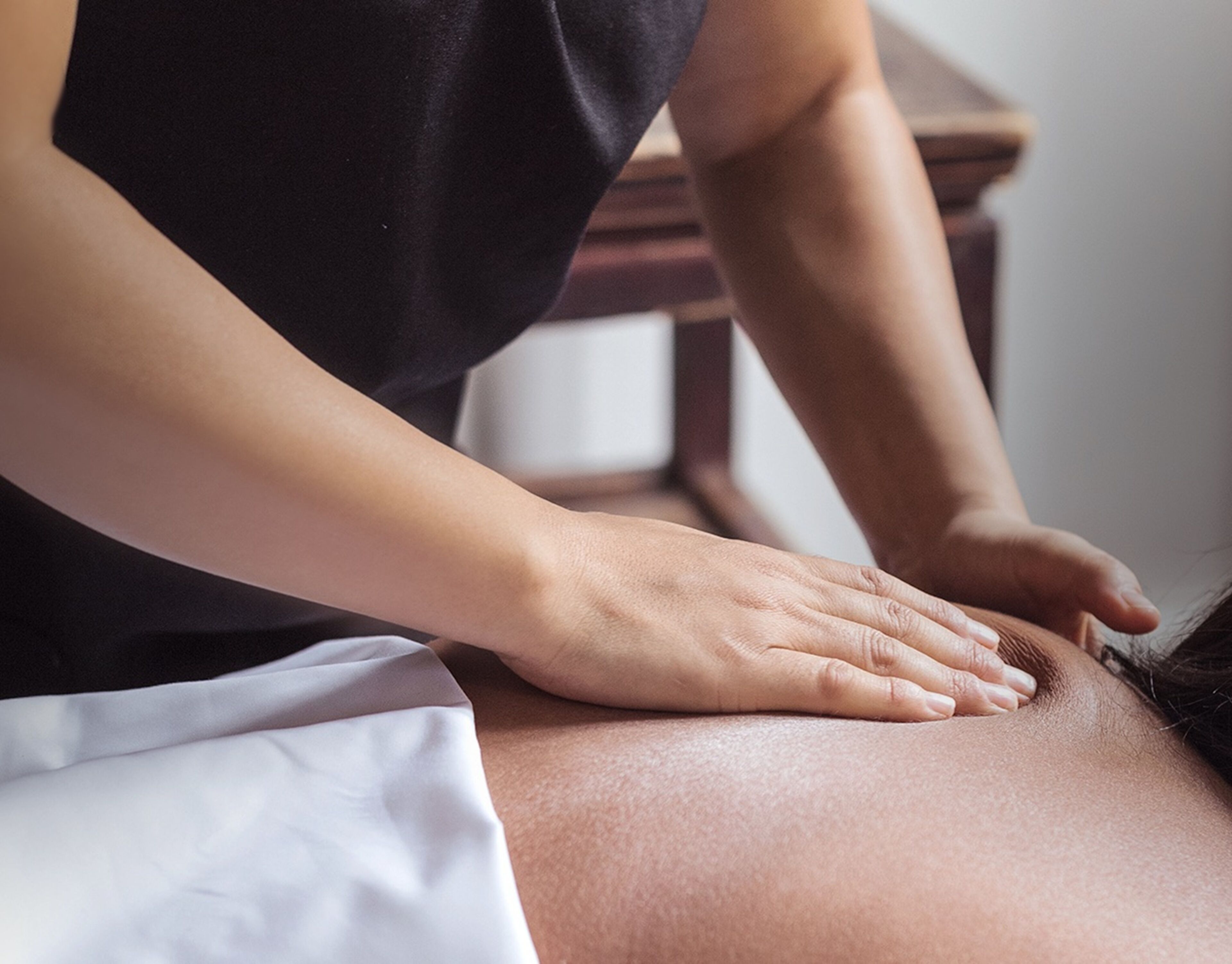 A person performing a massage on a client's back.