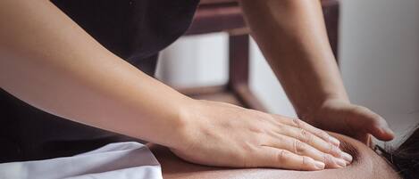 A person performing a massage on a client's back.