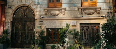 A historic building with three balconies, large wooden doors, and a sign reading "CANTINA."
