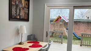 Een eethoek met een tafel, stoelen en een schilderij van een zebra op de muur.