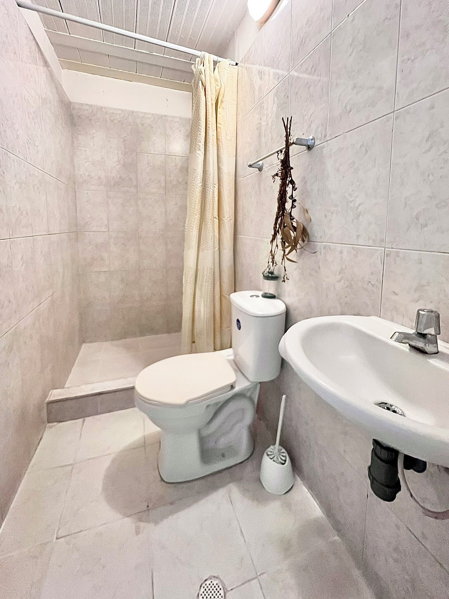 A bathroom with a toilet, sink, and shower.