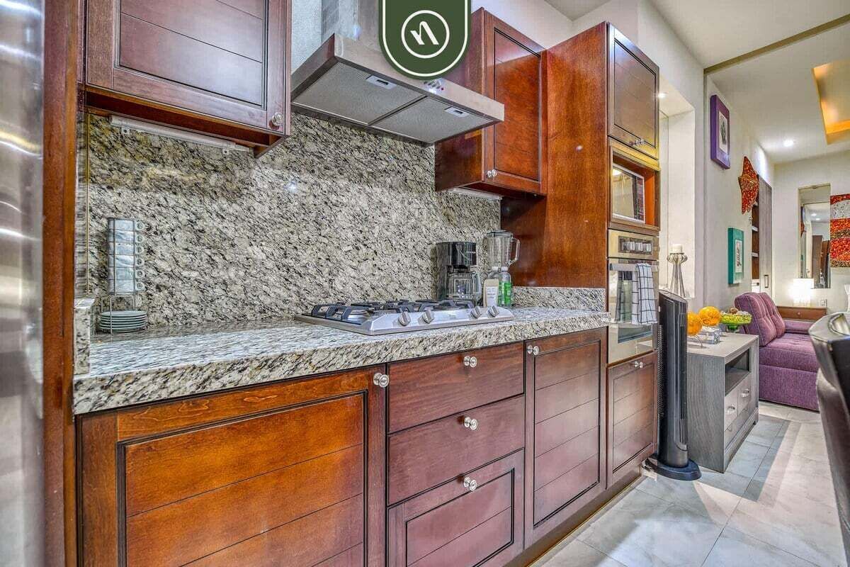 A kitchen with granite countertops, wooden cabinets, a gas stove, and a built-in oven.