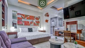 Une chambre d’hôtel moderne équipée d’un lit, d’un canapé, d’un coin repas et d’une télévision.