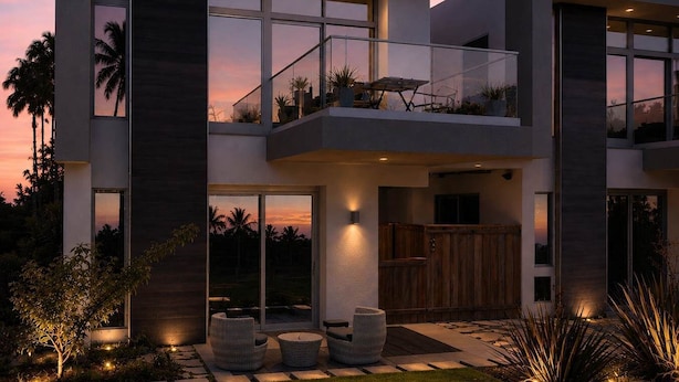 A modern two-story house with large windows, a balcony, and a well-lit outdoor seating area. - Stunning 4BR Villa with Bay Views & Rooftop Decks! (San Diego)