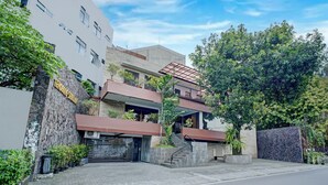 A modern building with a stone facade, a staircase leading to a second floor, and a gated entrance. - Collection O Near Mrt Cipete Raya (Jakarta)
