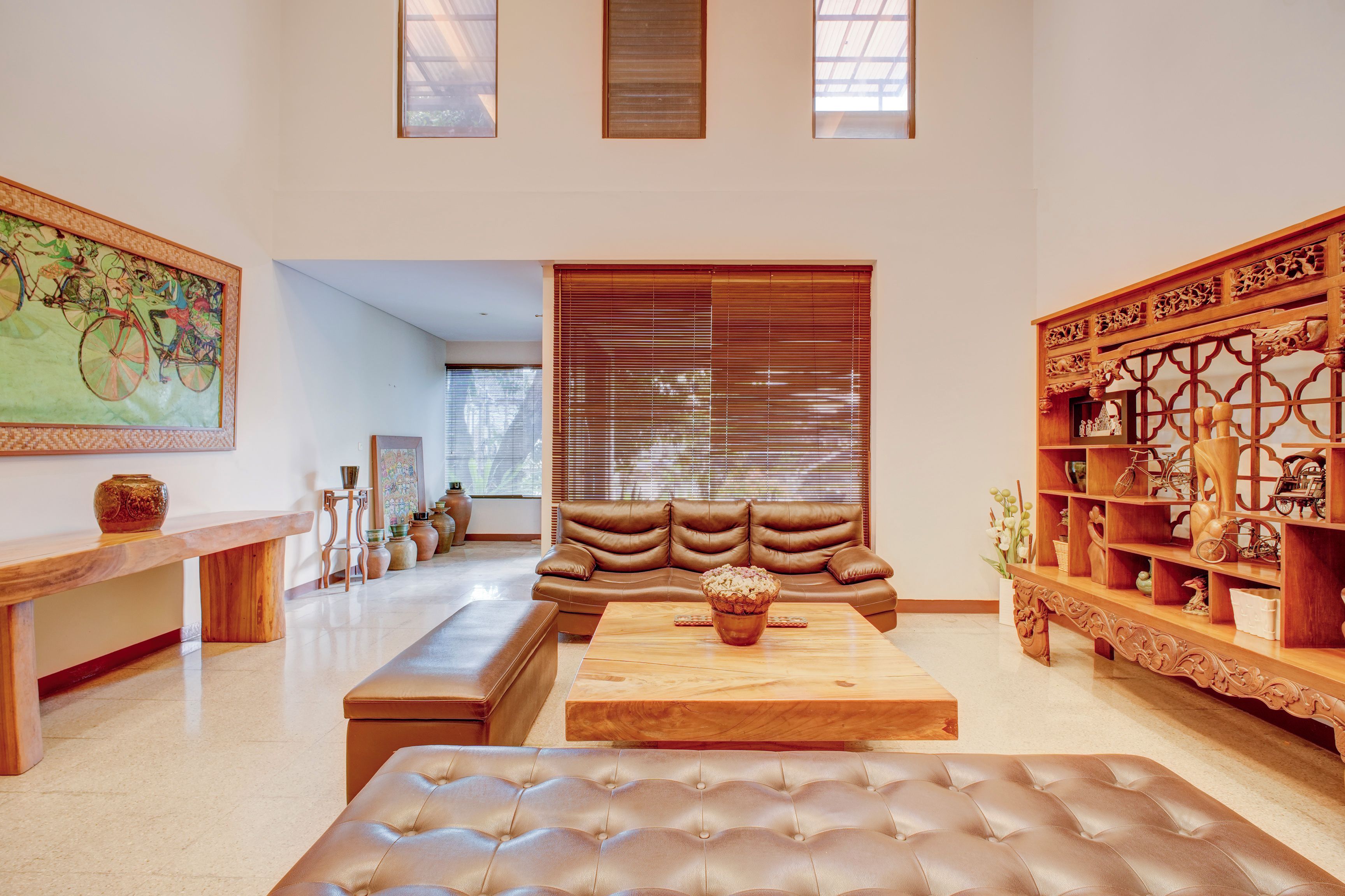 Een ruime woonkamer met een grote hoekbank, een houten salontafel en een decoratieve houten plank.