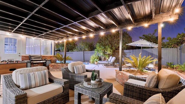 An outdoor patio area with wicker furniture, a barbecue grill, and a covered seating area. - Massive 5BR Resort Style Retreat with Heated Pool (San Diego)