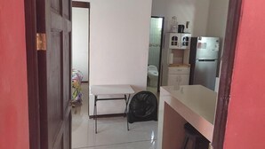 A compact kitchen with a white countertop, a small table, and a fan. - Centrally located and furnished apartment for short stays (San José)