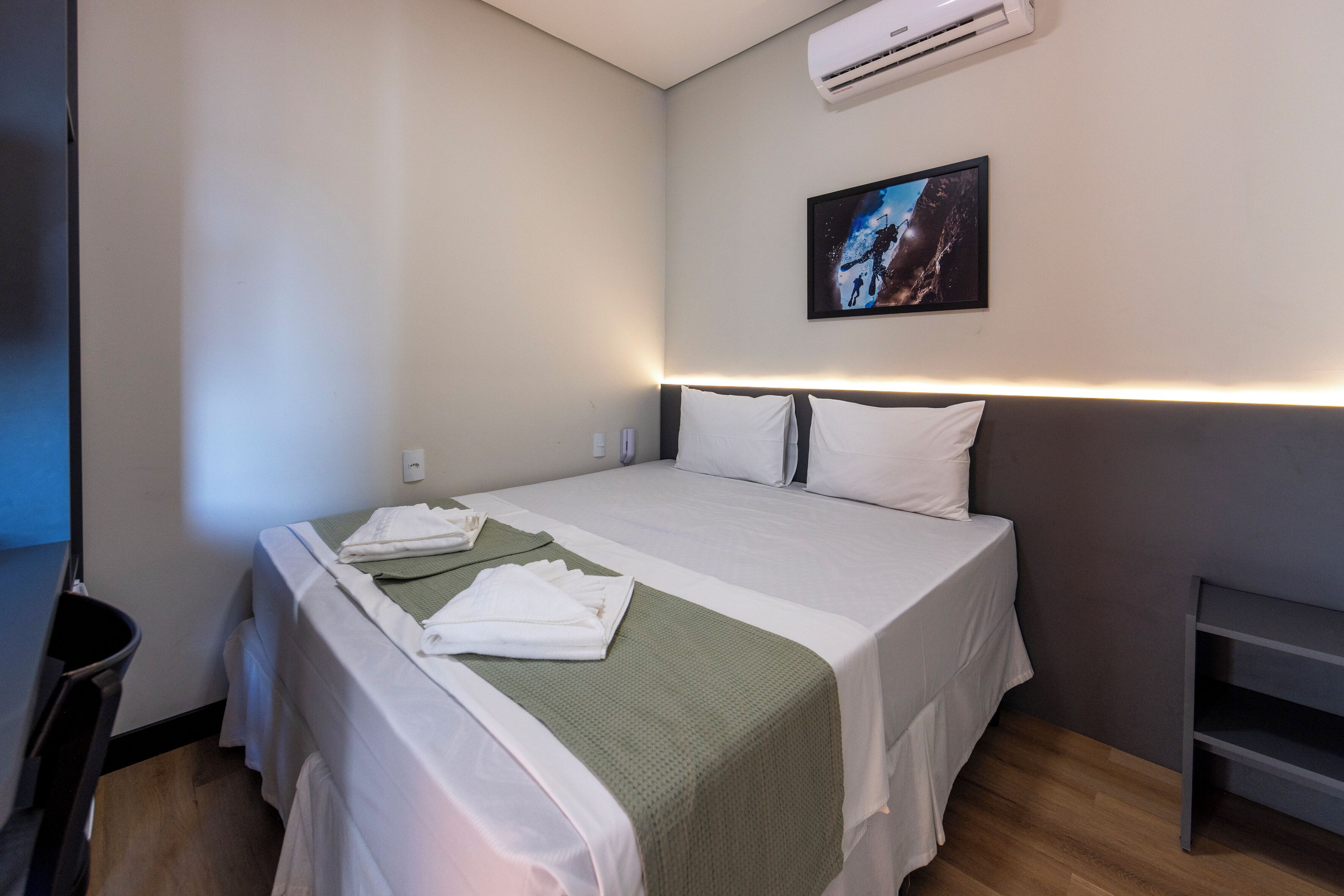 Une chambre d’hôtel avec un lit, un bureau et la climatisation.