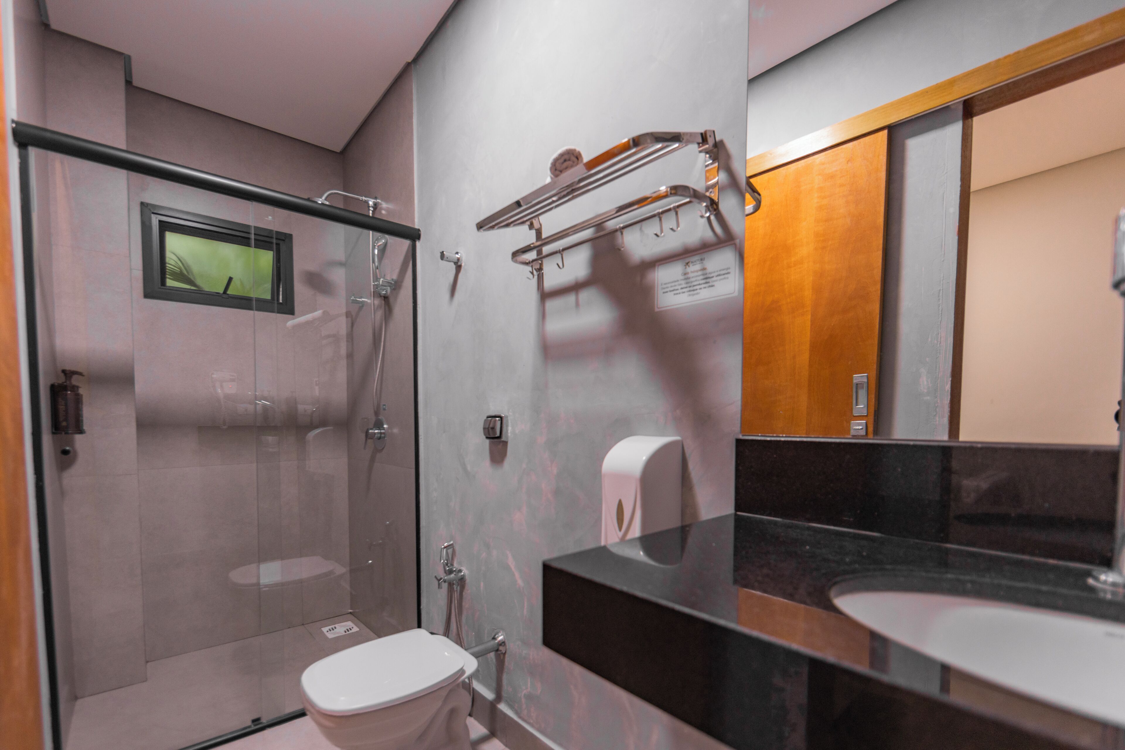 Un bagno moderno con doccia vetrata, un water e un mobile lavabo con specchio.