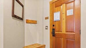 Un banco de madera, un espejo y una puerta con un letrero.