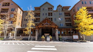 Un hotel de varios pisos con fachada de piedra, entrada de madera y un letrero que dice 'Buffalo Lodge'.